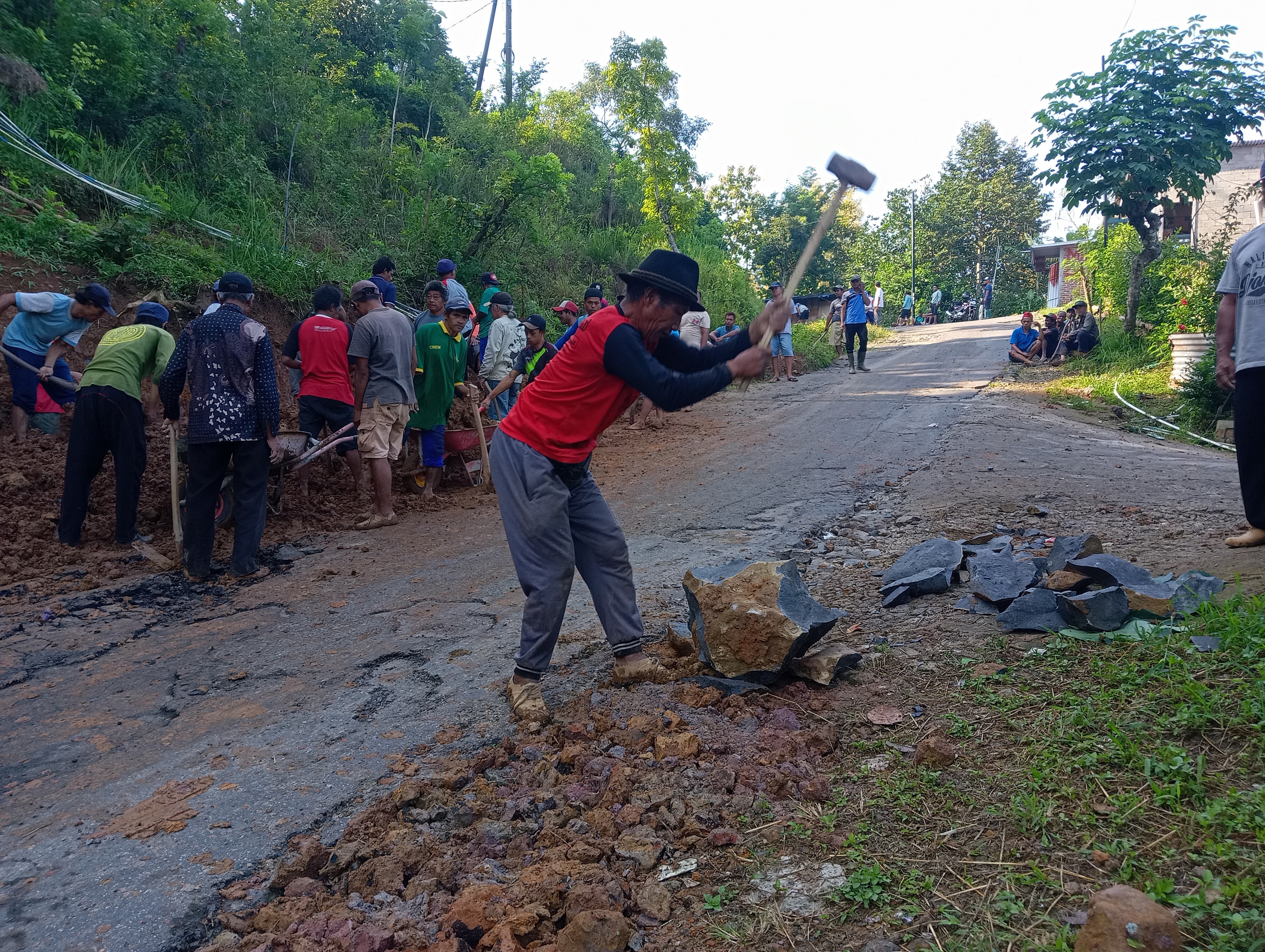 GOTONG ROYONG: Warga Desa Ngrogung, Ngebel, Ponorogo, Jawa Timur swadaya memperbaiki sendiri jalan di jalur menuju Telaga Ngebel dari arah Madiun, bekas tertimbun longsor 2022 lalu. (SUGENG DWI N.)
