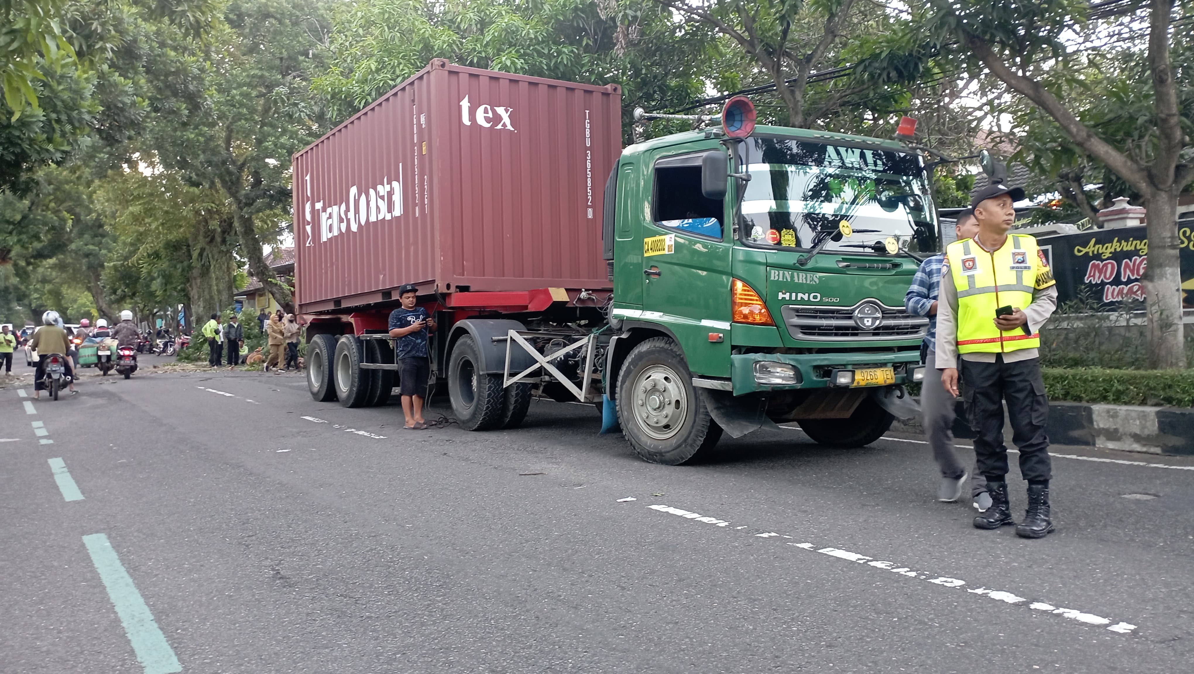 TUMBANG: Truk kontainer bernopol B 9266 TEI menyangkut pohon hingga menumbangkannya di Jalan Samudra Magetan, kemarin (7/5) pukul 16.00.