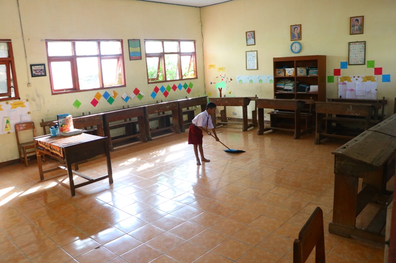 KOSONG: Siswa kelas II SDN Setono menyapu ruang kelas I yang seharusnya diisi siswa baru. (SUGENG DWI N./JAWA POS RADAR PONOROGO)