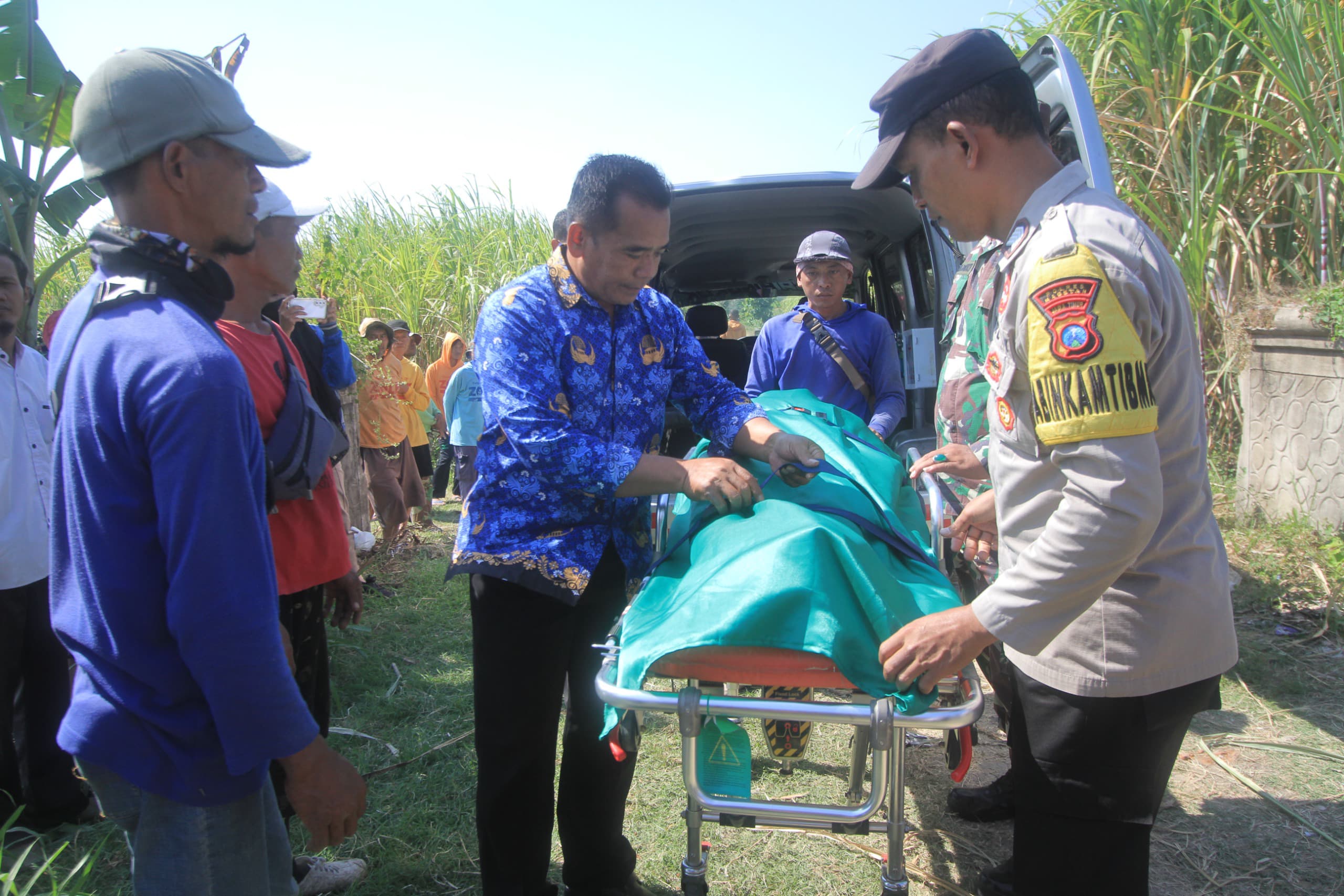 EVAKUASI: Petugas tim medis bersama TNI dan Polri mengevakuasi jasad buruh tebu di Desa Ngentep, Kecamatan Kawedanan. (AJI PUTRA/JAWA POS RADAR MAGETAN)