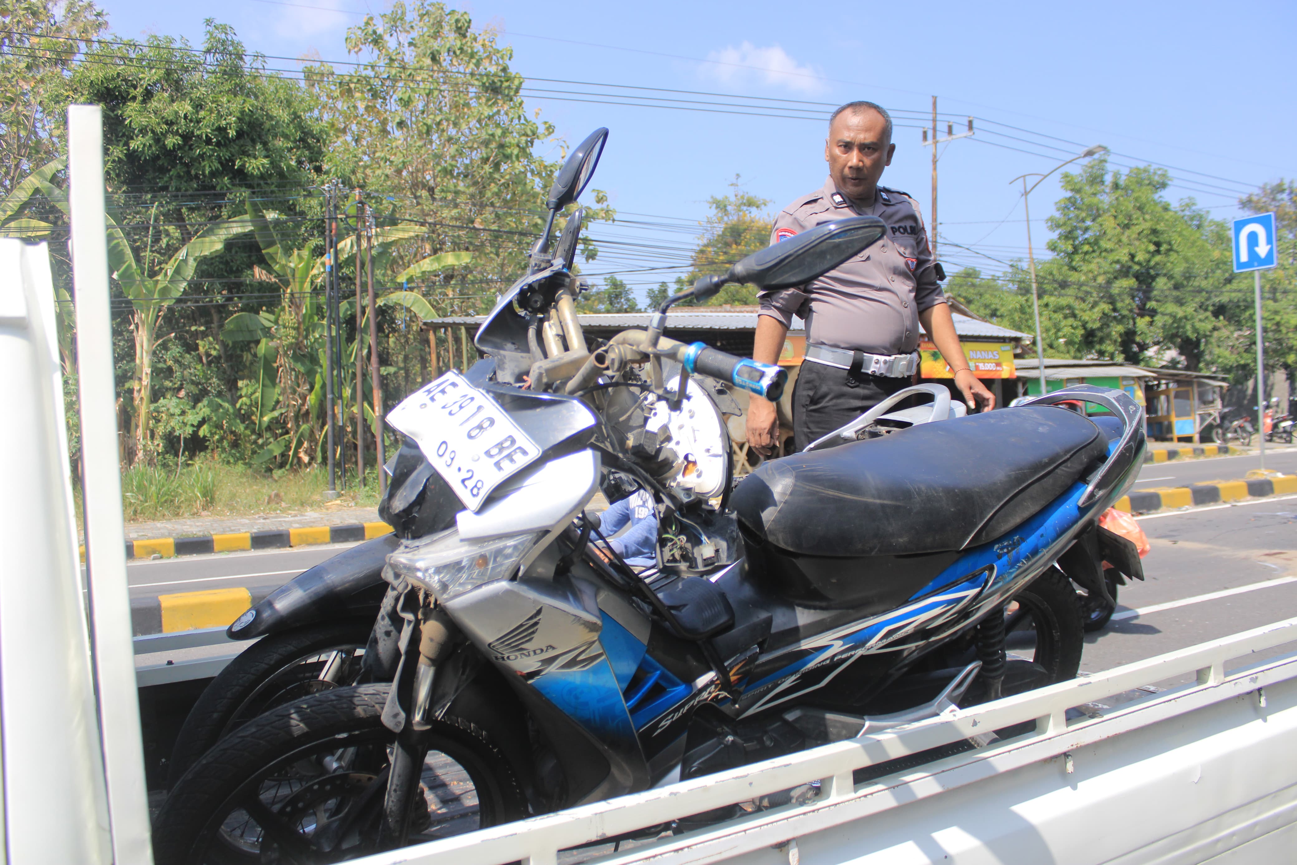 PENYIDIKAN: Petugas Satlantas Polres Magetan melakukan olah TKP kecelakaan lalu lintas di Jalan Raya Maospati- Magetan, Selasa (23/7). (AJI PUTRA)