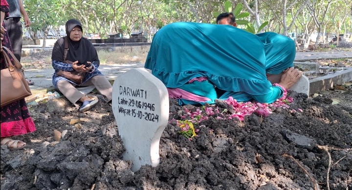 TERISAK DI MAKAM: Keluarga Darwati, 78, warga Desa Beran, Ngawi berziarah ke makam untuk berdoa agar almarhumah tenang. (ASEP SYAEFUL BACHRI/JAWA POS RADAR NGAWI)