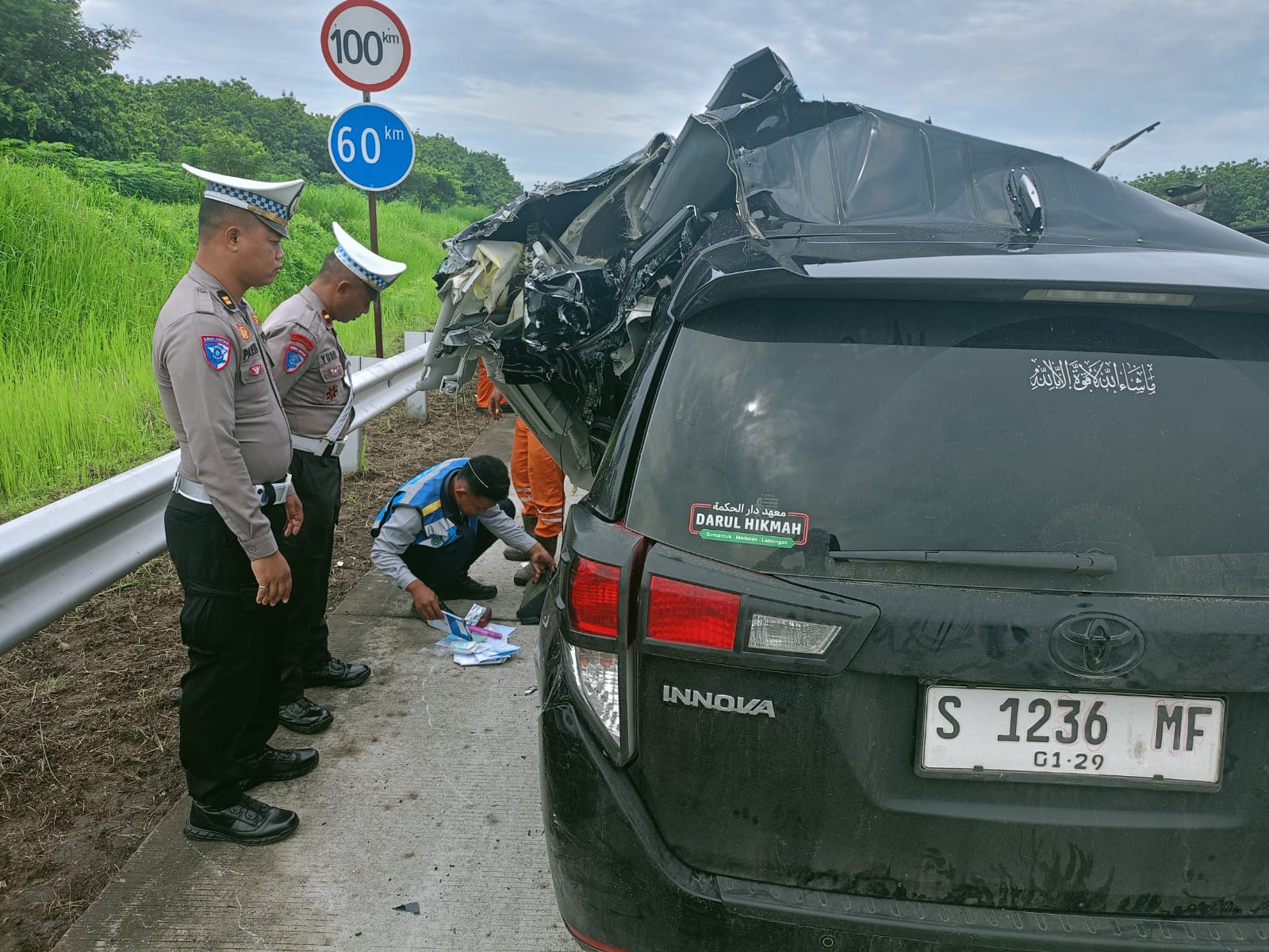 OLAH TKP: Polisi mengecek kondisi mobil Innova yang terlibat kecelakaan dengan truk di Tol Solo-Ngawi Km 522, Senin 16 Desember 2024.