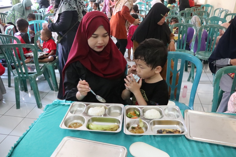 GENERASI EMAS: Ibu hamil dan anak-anak mendapatkan makanan bergizi gratis pada uji coba program makan bergizi gratis (MBG) di Ponorogo, Jawa Timur beberapa waktu lalu.&nbsp;