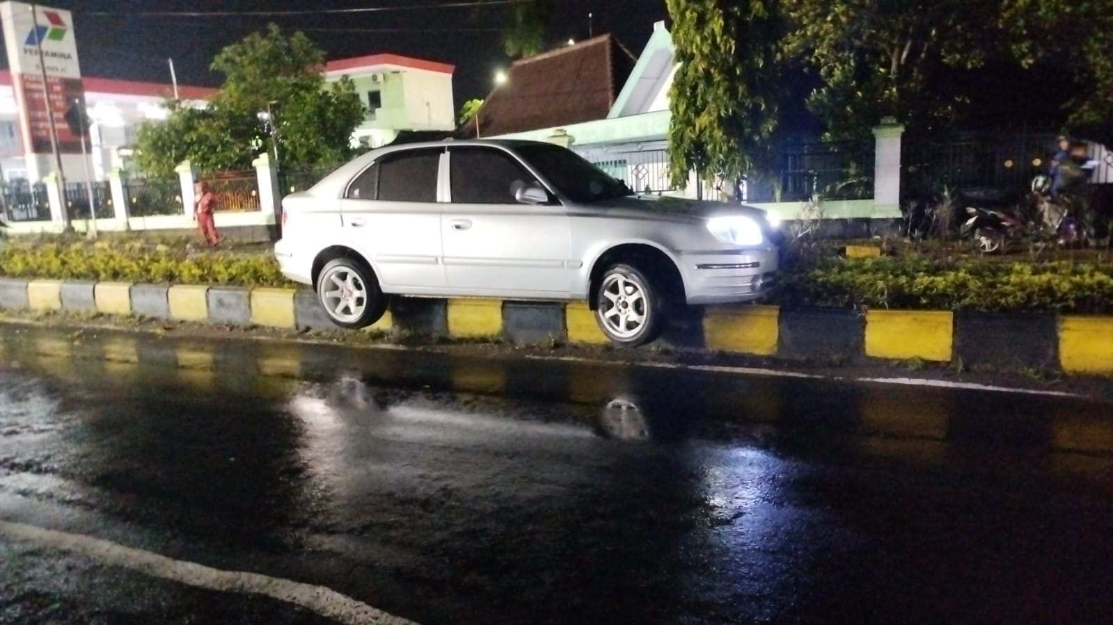 Mobil Hyundai Avega nangkring atau nyangkut di pembatas Jalan Raya Maospati Sukomoro, Magetan, Selasa malam, 14 Januari 2025.