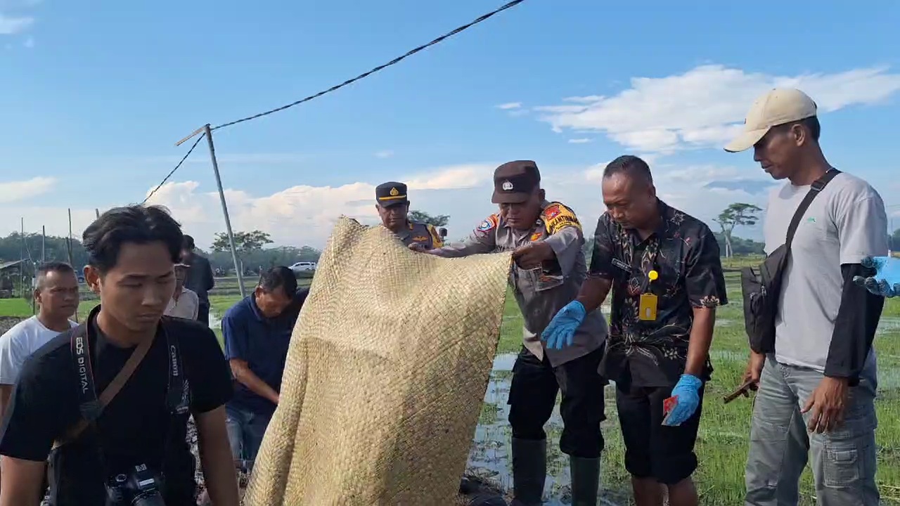 EVAKUASI: Petugas Polsek Geneng mengevakuasi jasad pria diduga kena jebakan tikus beraliran listrik di Desa Klitik, Ngawi, pada Minggu (19/1).