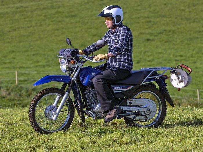 Yamaha AG125 tampil dengan desain klasik ala motor trail, lengkap dengan rak depan-belakang dan fitur tangguh untuk medan perkebunan.