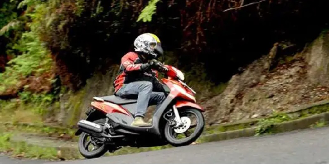 Ilustrasi motor Mio Sporty melaju di tanjakan.