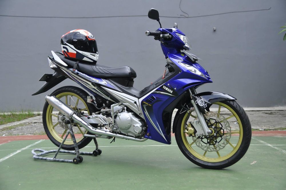 Yamaha Jupiter MX generasi pertama, dibekali radiator dan 5-percepatan manual, pelopor motor bebek performa tinggi.