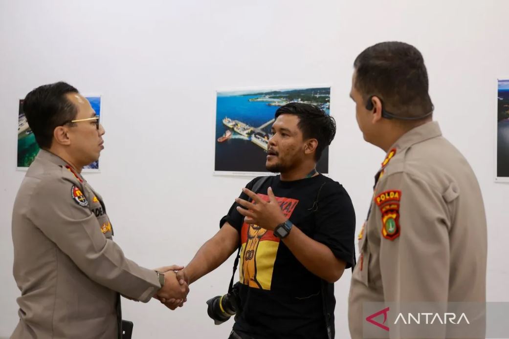 Pewarta foto ANTARA Bayu Pratama berjabat tangan dengan Kabid Humas Polda Metro Jaya Ade Ary Syam Indradi usai insiden kekerasan saat liputan Aksi 25 Agustus 2025 di Jakarta.