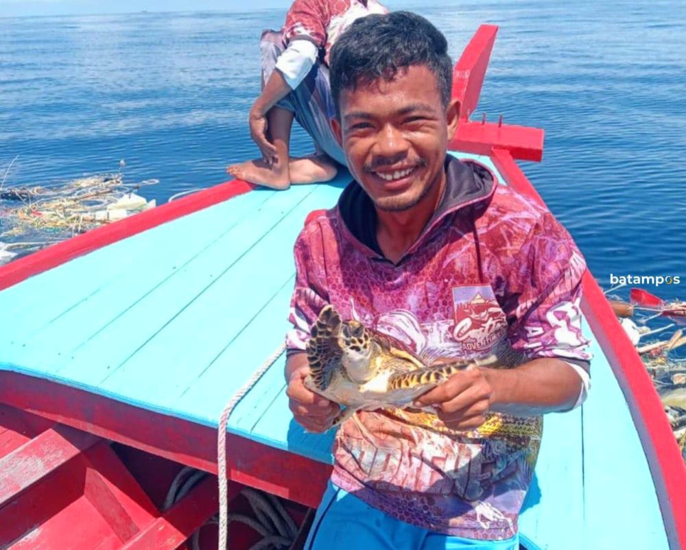 Andrika, nelayan Jemaja, angkat penyu hijau dari jaring dan sampah Teluk Sadang aksi penyelamatan yang bikin haru dan viral. (Sumber: Batam Pos)