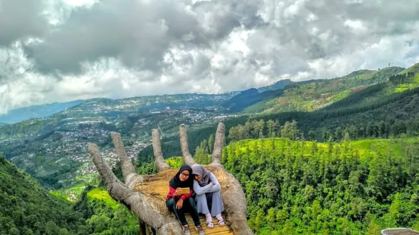 Bukit Ada Apa Dengan Tukung terkenal dengan deretan spot foto unik seperti tangan raksasa, sarang burung, dan gardu pandang tepi tebing.