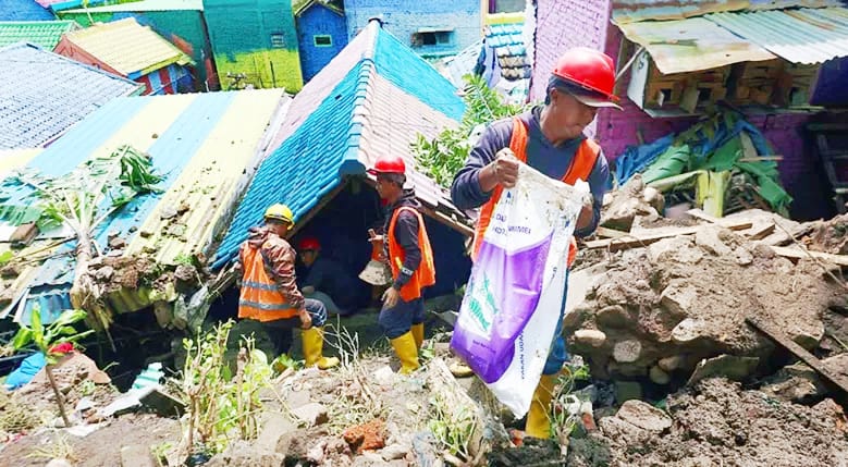 Pembersihan Rumah warga di Kelurahan Kesatrian rusak parah usai diterjang longsoran dari Jembatan Embong Brantas. (Sumber: Radar Malang)