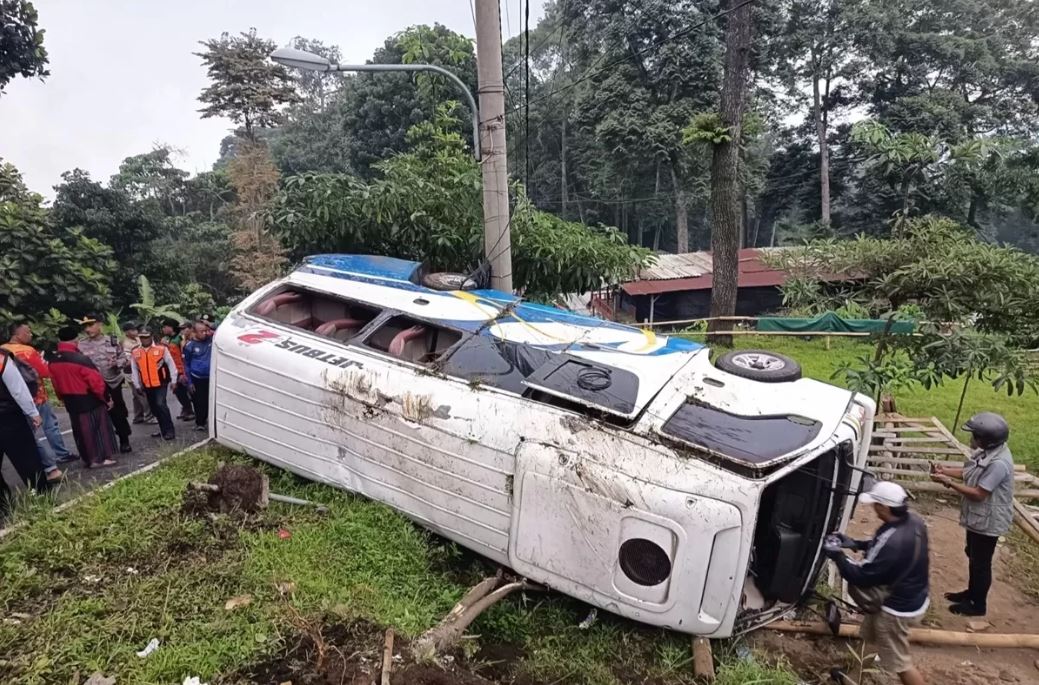 Diduga rem blong, Elf rombongan keluarga asal Surabaya terguling di Pacet, Mojokerto, Kamis sore (1/1).