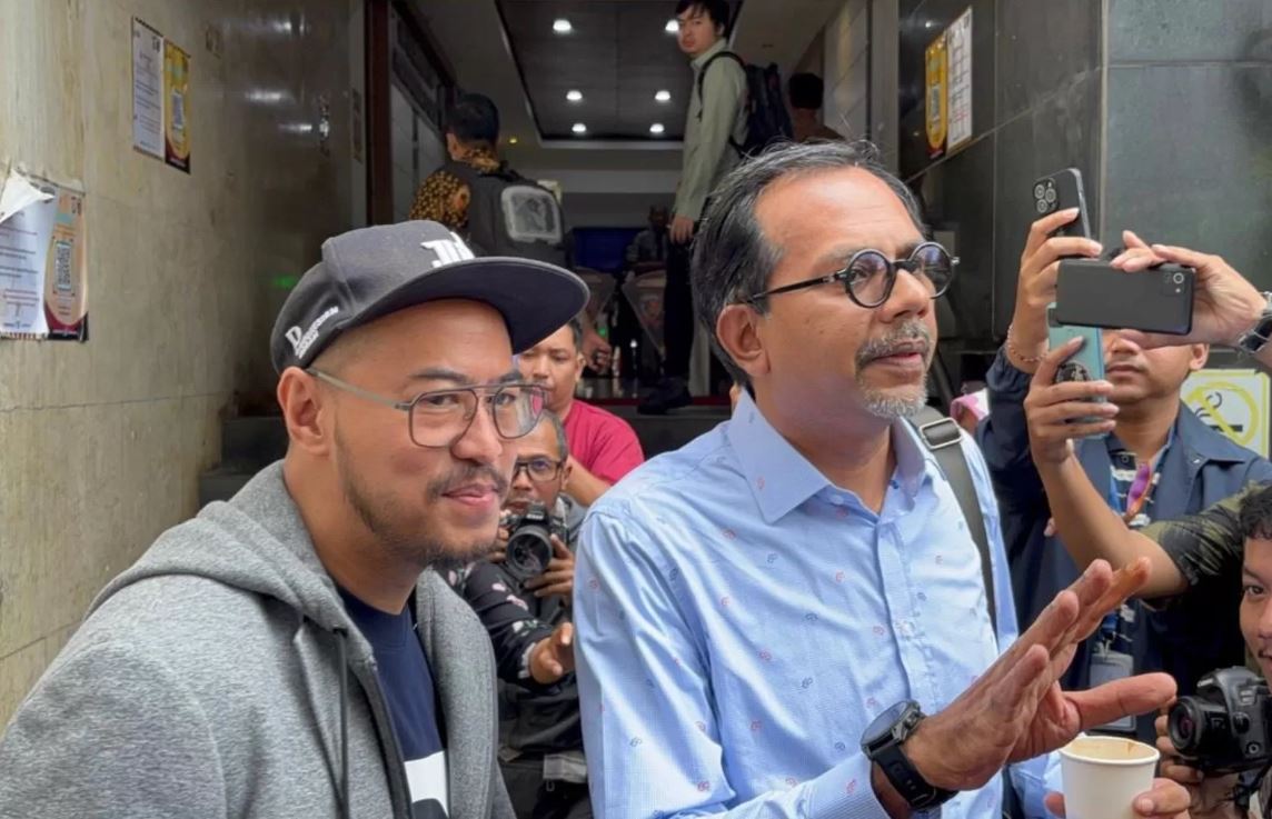 Komika Pandji Pragiwaksono tiba di Polda Metro Jaya pada Jumat (6/2). Dia datang bersama pengacaranya, Haris Azhar.