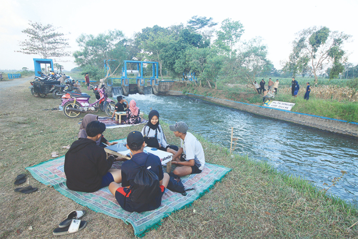 Pengunjung menikmati kopi di skitar Dam Slorot Jember. (Foto Dok Radar Jember)
