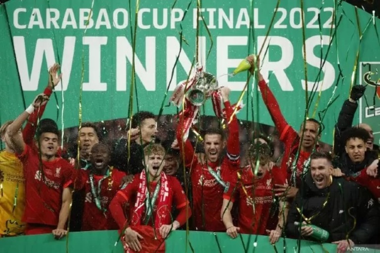 Kapten Liverpool Jordan Henderson mengangkat Piala Carabao usai mengalahkan Chelsea lewat adu penalti pada Senin (28/2/2022). (John Sibley/Reuters/Antara)