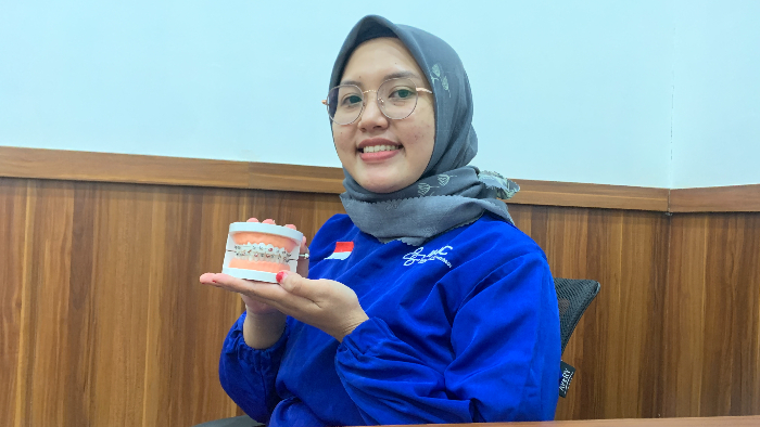 BERI PENJELASAN: Dokter gigi Rolas Dental Care Jember, drg Riskyana Dwi Hendra, menunjukkan replika gigi manusia. ILHAM WAHYUDI/RADAR JEMBER