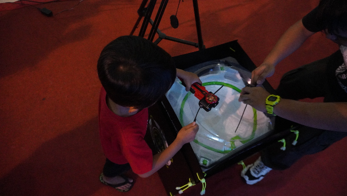 TAK PANDANG USIA: Keasikan bermain gasing Beyblade tak hanya dilakukan anak-anak namun juga orang dewasa. (Tri Joko S/ Radar Jember)
