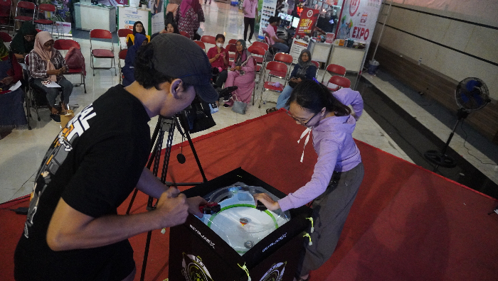 TANDING: Penghobi mainan antusias mengadu gasing Beyblade-nya di Balai Serbaguna Kaliwates. (Tri Joko S/ Radar Jember)