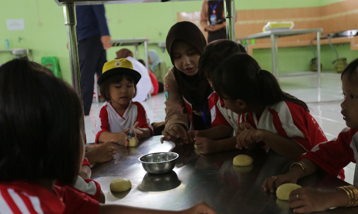 PRAKTEK LANGSUNG: Siswa TK Bustanul Ulum Kasiyan mencoba membuat adonan kue di SMKN 5 Jember. ILHAM WAHYUDI/RADAR JEMBER