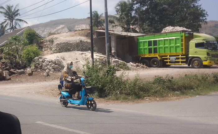 PAKAI MASKER: Pengendara motor harus antisipasi polusi bila melewati Jalan Yani 32, Kecamatan Puger, (18/7). ABDUL MUIZ/RADAR JEMBER