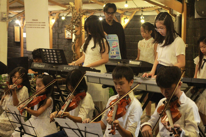 MEMUKAU PENGUNJUNG: Siswa Sekolah Tiga Bahasa Rukun Harapan menampilkan musik orkestra dalam acara pameran seni Museum Cahaya. MOCH AFFANDI