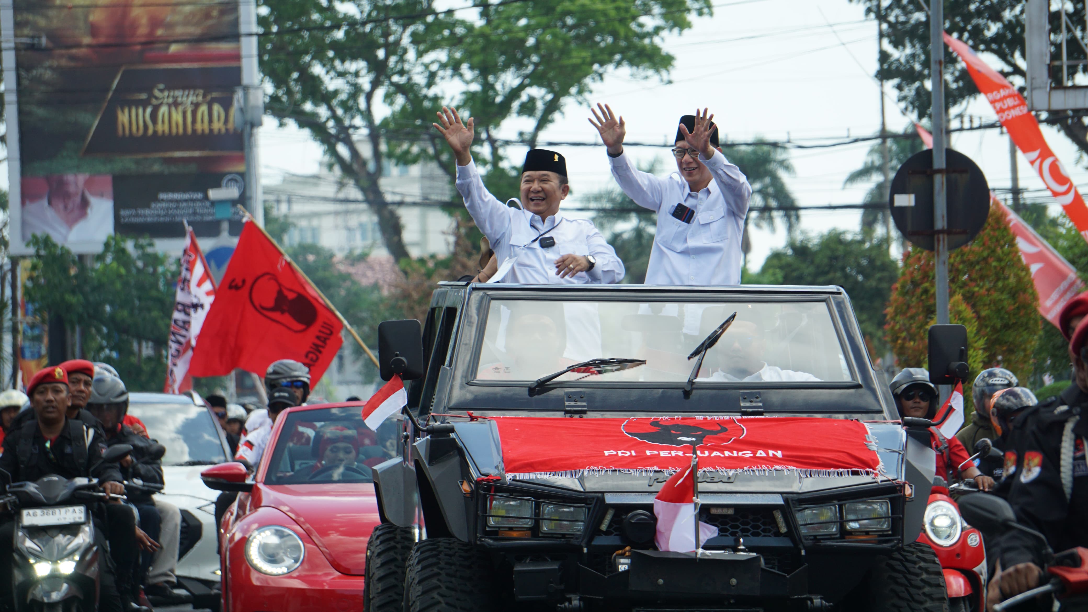 Hendy Siswanto dan Gus Firjaun menyapa warga saat mendaftarkan diri ke KPU sebagai Paslon di Pilkada Jember.  (YULIO./RADAR JEMBER)