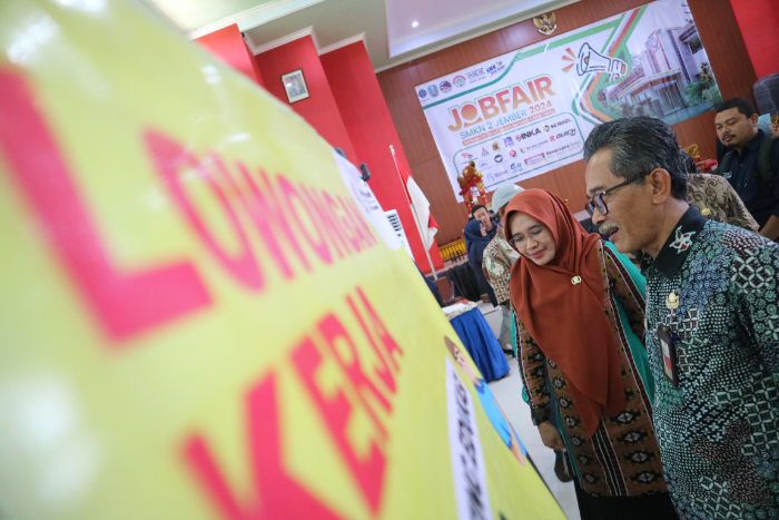 BUKA KESEMPATAN KERJA: Kepala Disnaker Jember Suprihandoko bersama Plt Kepala SMKN 2 Jember Evi Silviana mengecek kesiapan perusahaan dalam membuka lowongan kerja dalam Job Fair di aula SMKN 2 Jember,