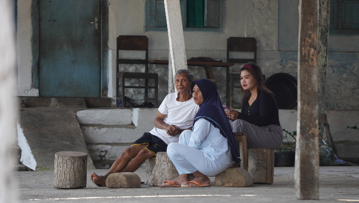 Warga Kampung Belgia Jember sedang duduk santai di depan rumah