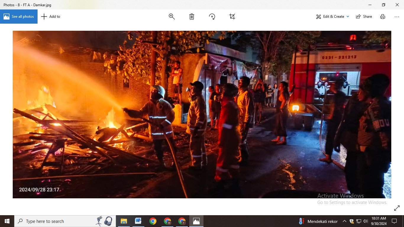 PADAMKAN API: Petugas Damkar Mako B berjibaku memadamkan api yang membakar kios kayu dan mebel, Sabtu (28/9) pukul 23.00. (DAMKAR/RADAR JEMBER)