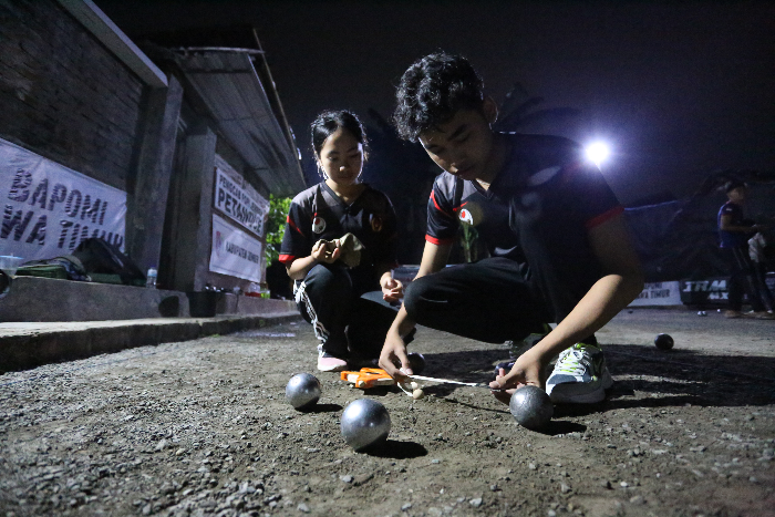 Atlet petanque Jember, Susviatun Andini (kiri) bersama rekannya menghitung jarak hasil lemparannya dalam sesi latihan di lapangan petanque Jember, Kelurahan Slawu, Kecamatan Patrang, Kamis (31/10).