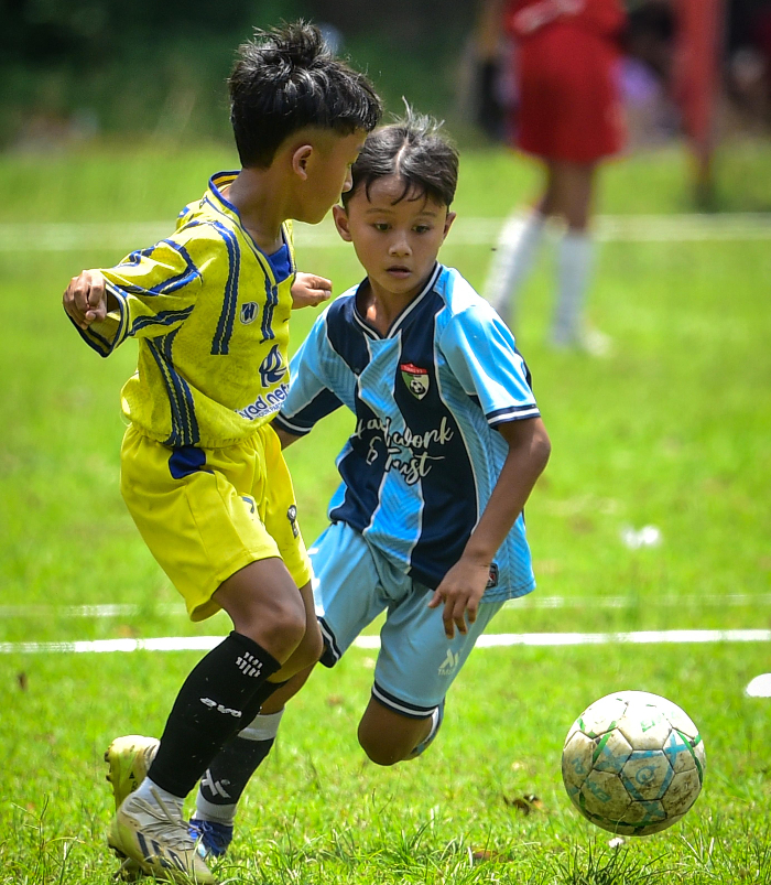 Tim JFoS U-10 (biru/kanan) mencoba mengambil bola dari pemain Tunas 92 Banyuwangi pada laga final Liga Anak Indonesia Regional Jember U-10, RENDRA KURNIA/LIGA ANAK INDONESIA