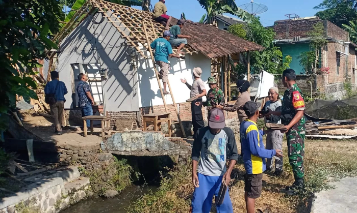 LAYAK HUNI: Anggota Polsek dan Koramil Patrang bersama warga sekitar saat melakukan perbaikan rumah pada 2023 lalu. Kondisi rumah dari gedek dengan lantai tanah saat ini jarang ditemui di Jember.