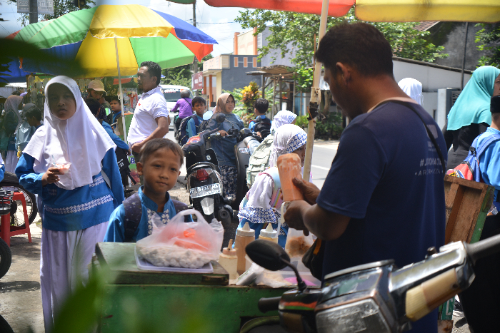 JAJANAN SEGALA USIA: Pedagang cilok tengah melayani pembeli dari kalangan pelajar. ADHI SURYA/RADAR JEMBER