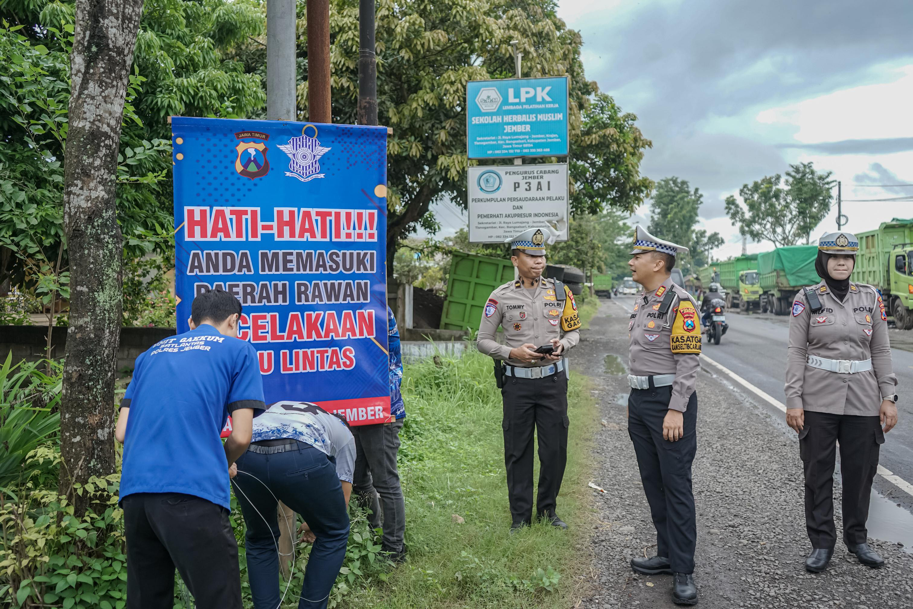 DITANDAI: Polisi saat memberikan penanda imbauan agar pengendara lebih berhati-hati melintasi sekitar jalan raya Langkap, Kecamatan Bangsalsari. SATLANTAS POLRES JEMBER