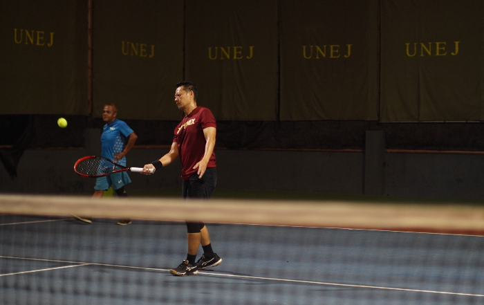 TAMPIL BUGAR: Di usia yang tak lagi muda, atlet tenis veteran, Kwang Kwang, tampil lincah dalam kompetisi tenis three on three di lapangan tenis Universitas Jember, Selasa malam (26/2). YULIO FA/RADAR