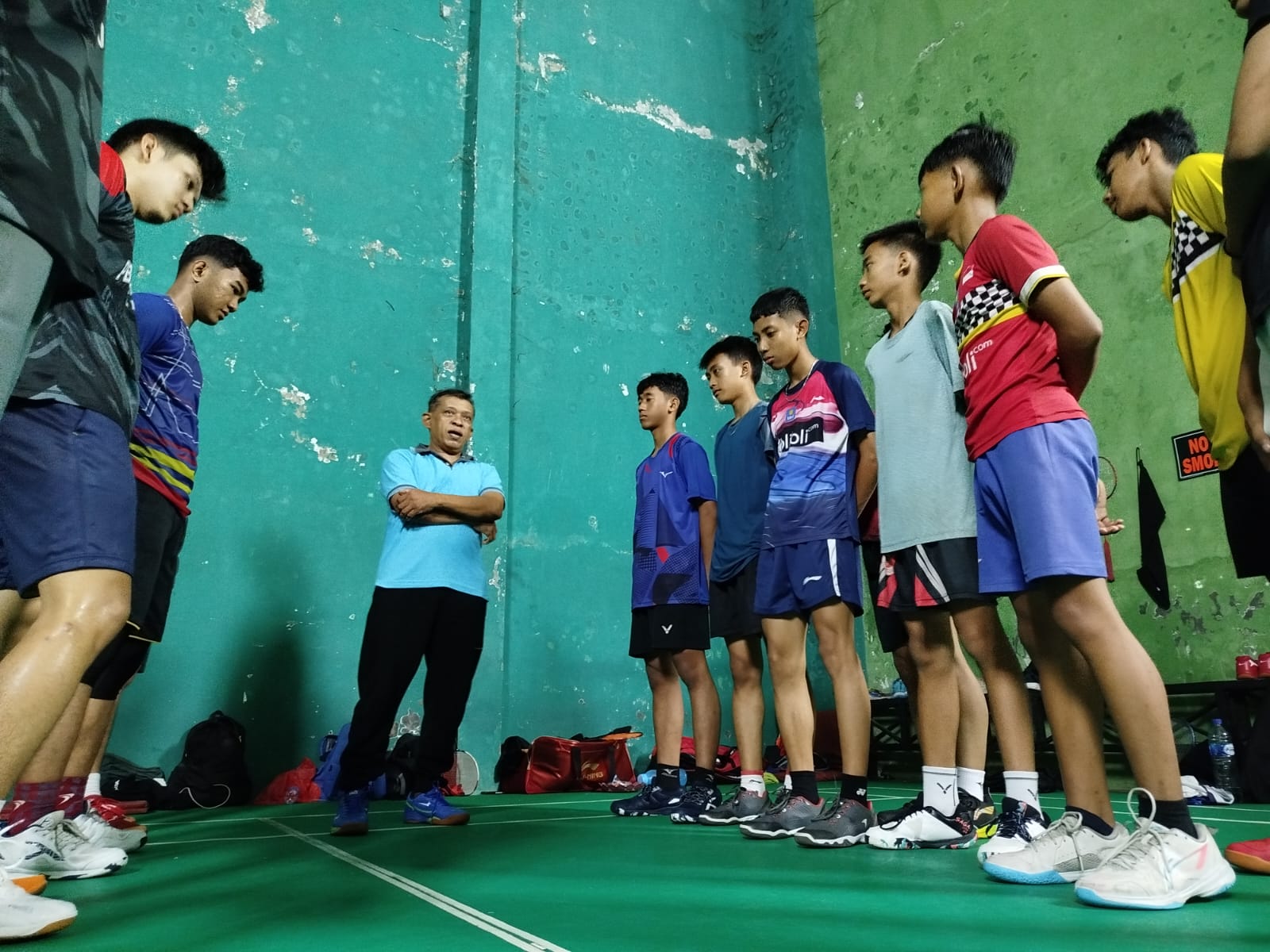 GIAT: Pelatih bulu tangkis memberikan pengarahan ke atlet junior (kanan) dan senior (kiri). YULIO FA/RADAR JEMBER  &nbsp;