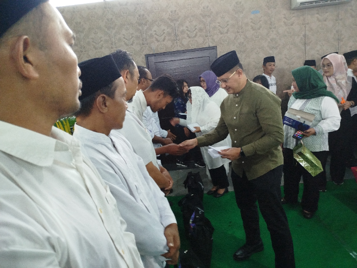 INDAHNYA BERBAGI: Kepala Dispendik Jatim Aries Agung Paewai beserta jajarannya memberikan santunan kepada satpam hingga petugas kebersihan SMKN 5 Jember, Selasa kemarin (11/3). DWI SIS/RADAR JEMBER