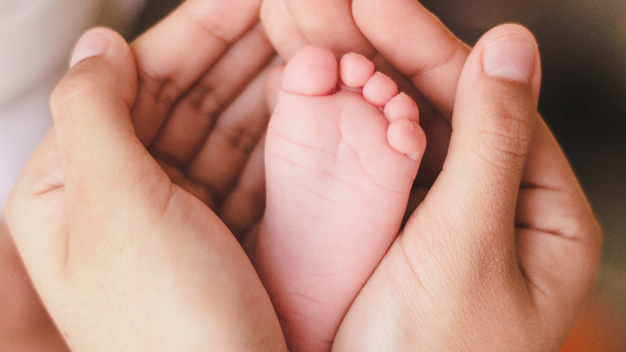 Mencium tangan dan kaki bayi berisiko menularkan penyakit (Canva)