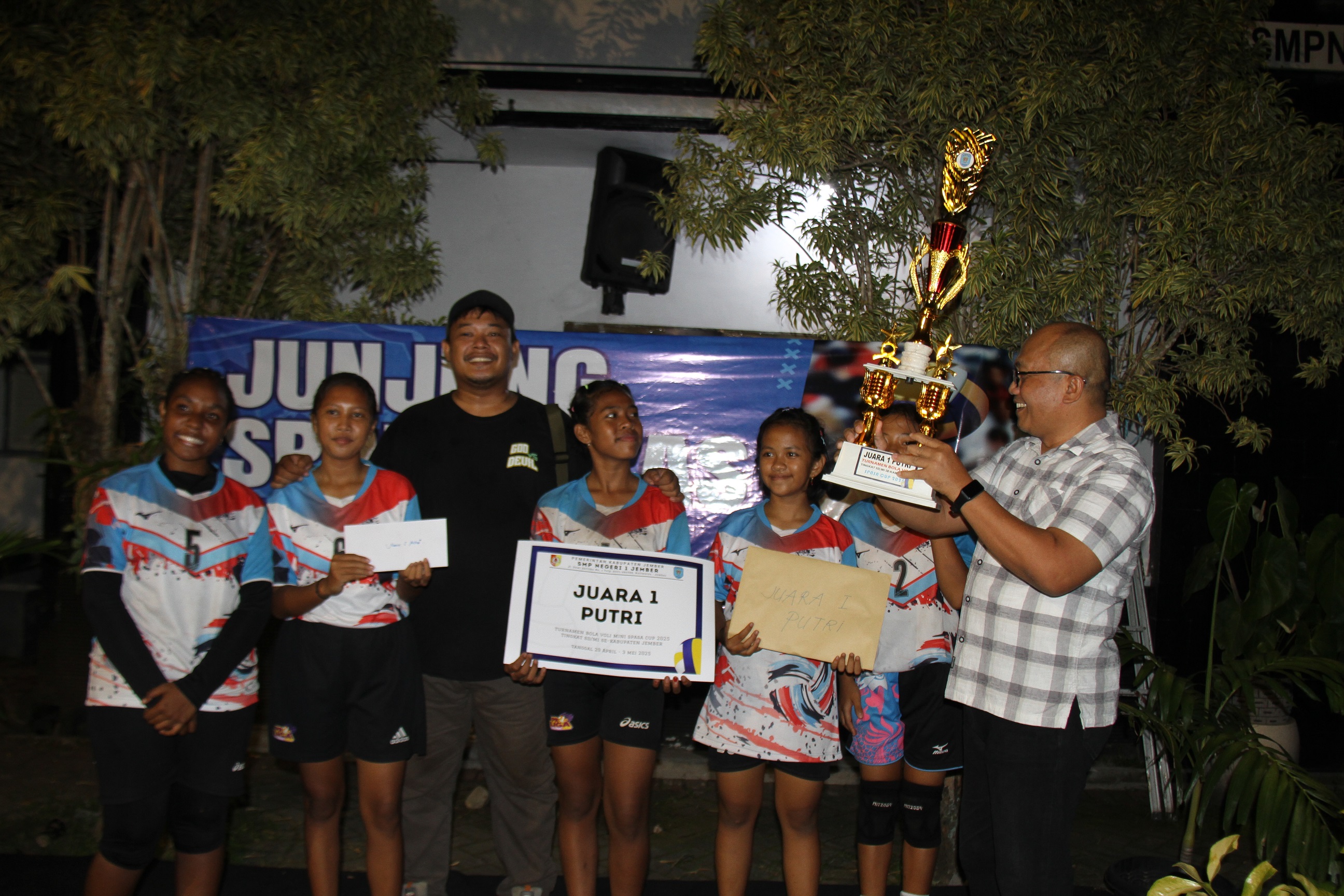 MEMBANGGAKAN: Plt Kepala SMPN 1 Jember M Rokhim menyerahkan trofi kepada juara 1 Spasa Cup 2025 tim Putri Bola Voli SDN Sidorejo 01, Kecamatan Umbulsari. (JUMAI/RJ)