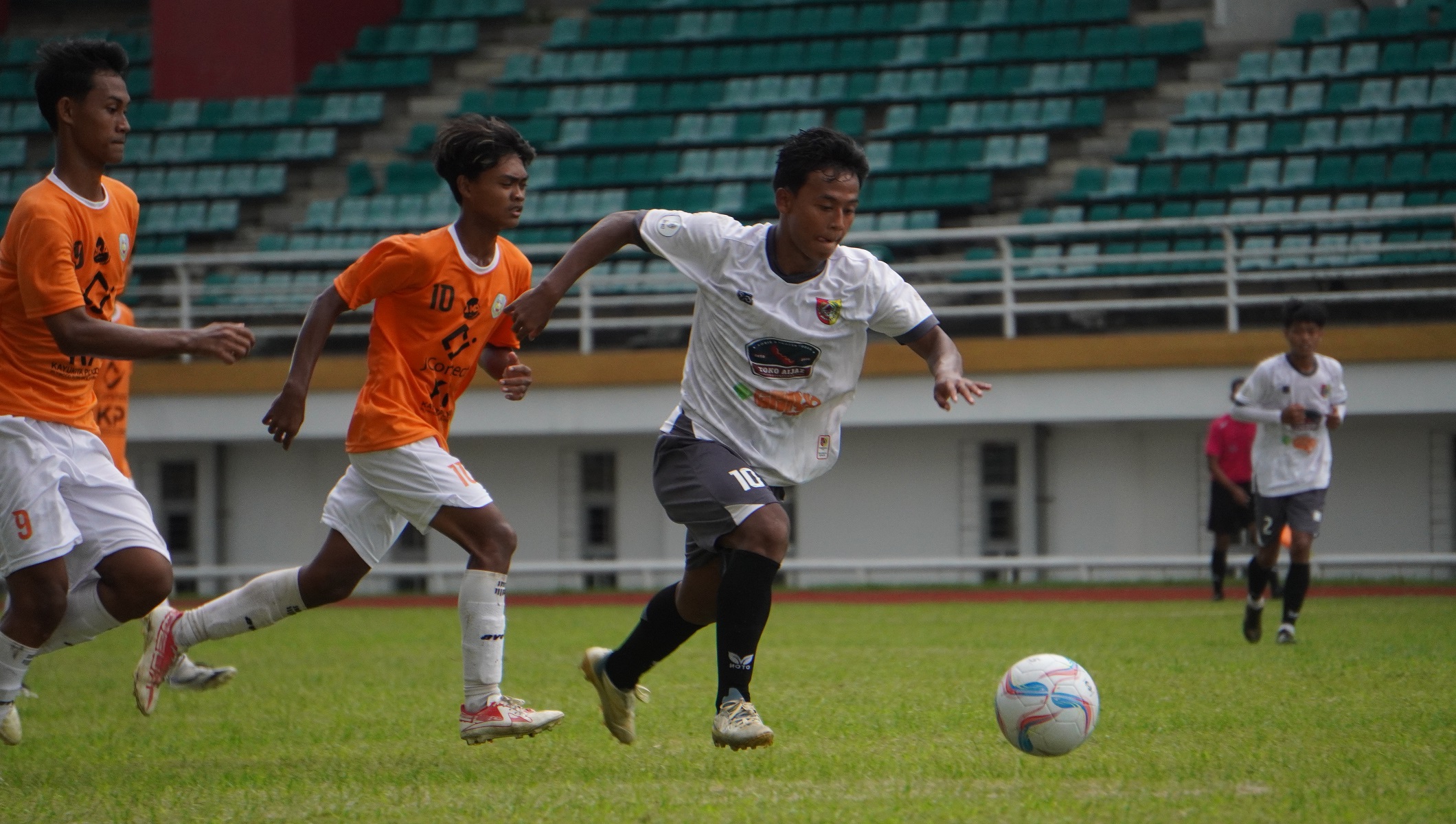 Pemain Jember (putih) membawa bola saat pertandingan Pra Porprov melawan Situbondo di Stadion JSG Jember, Selasa (20/5). (Yulio FA/Radar Jember)