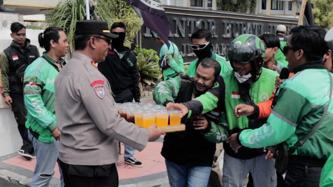 Polisi Jember yang mengawal demo ojol juga memberikan minuman dingin.
