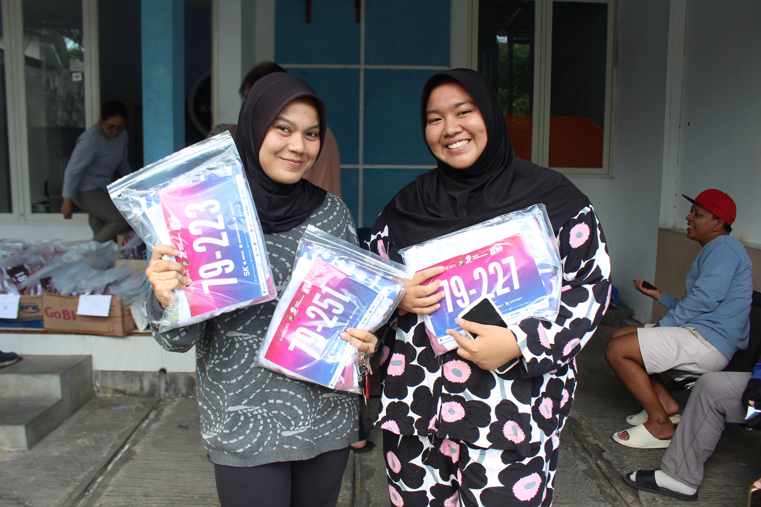 Dua runner perempuan mengambil perlengkapan lari Ijen BRO yang akan dihelat Minggu, hari ini.
