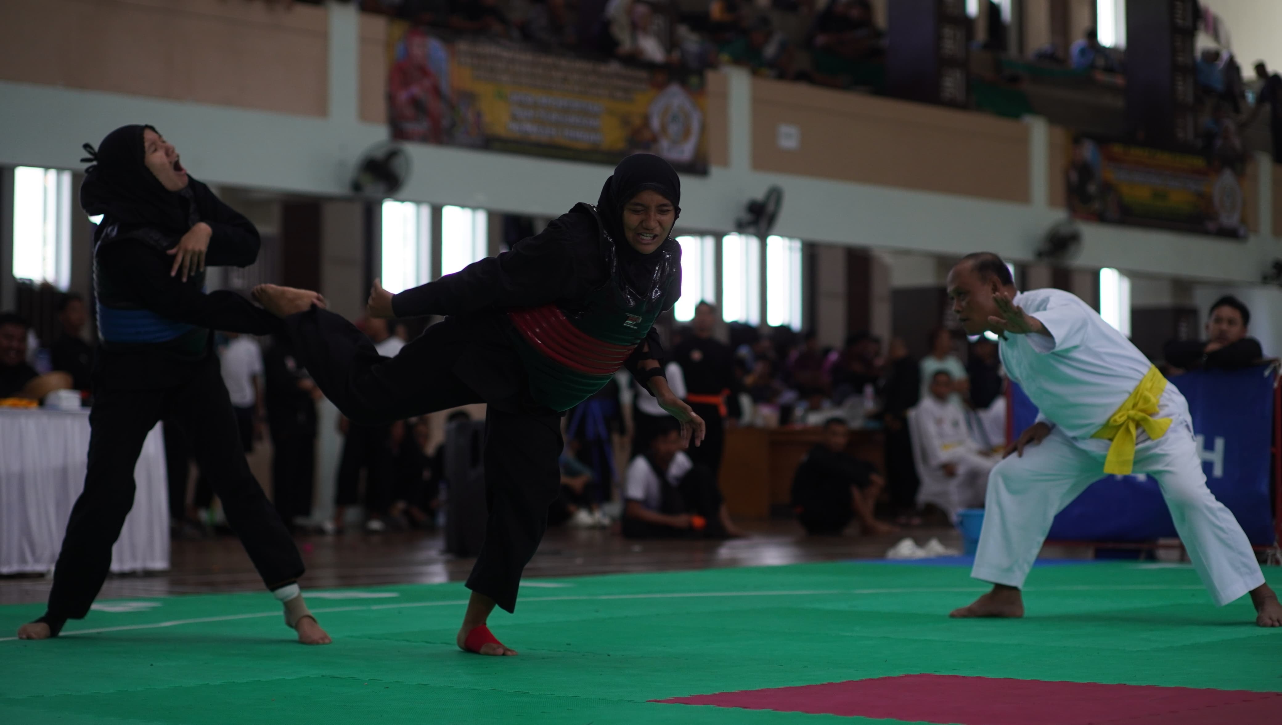 Pesilat Jember, Ajeng Permatasari (kanan) saat melakukan tendangan ke pesilat Ngawi, kemarin (2/7) di Sport Center UIN Maulana Malik Ibrahim, Kota Malang.
