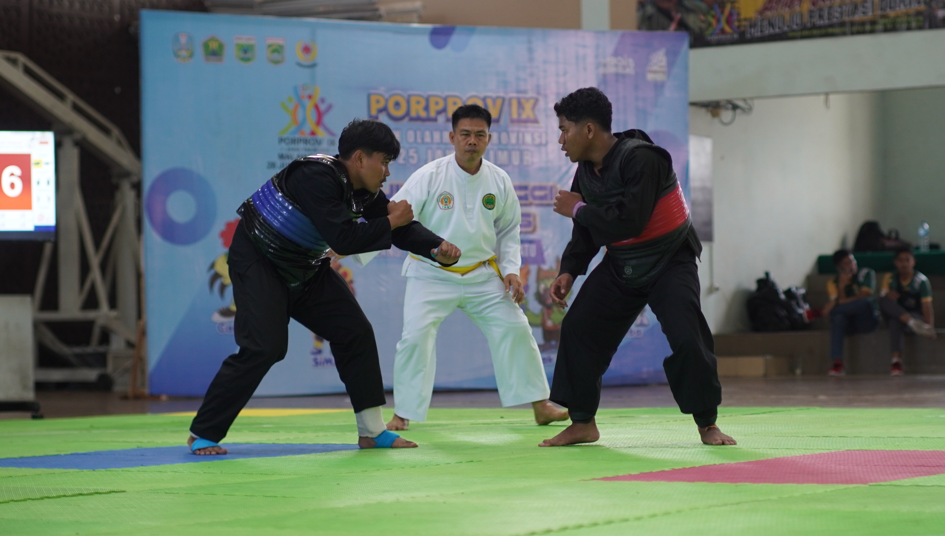 Atlet Pencak Silat Jember kubu biru (kiri) kalah sebelum masuk perempat final dalam laga Porprov di Kota Batu, pekan lalu. Kali ini peringkat Jember merosot ke-20.