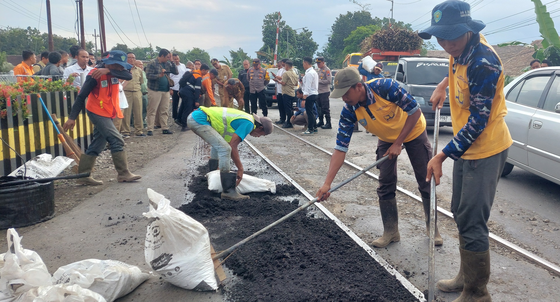 Tim URC Jember saat memperbaiki jalan rusak di perlintasan rel KA di Desa Pecoro, Kecamatan Rambipuji, Senin lalu. Maka hati-hati saat melintasi rel ini, terutama saat hujan dan malam hari.