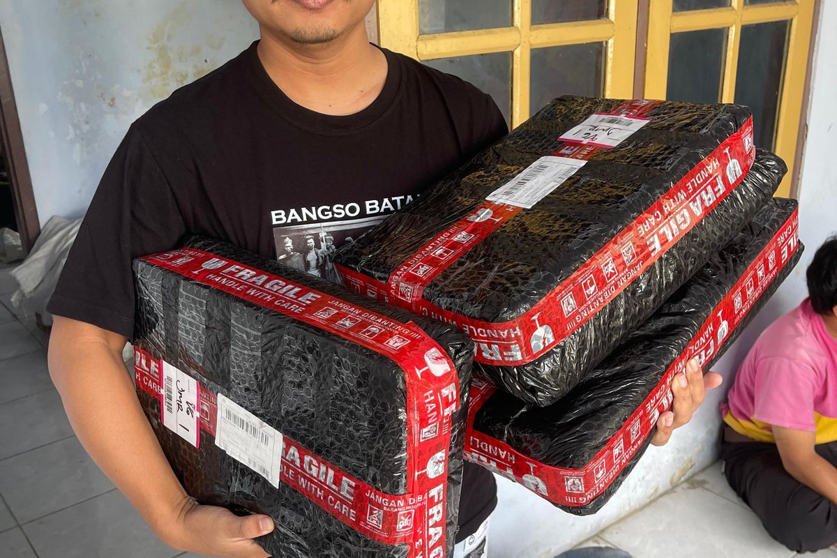 Agus Hariyanto menunjukkan paket yang diterima. Influencer Lumajang ini terima paket COD meski tak pernah memesannya. Diduga jadi korban doxing.