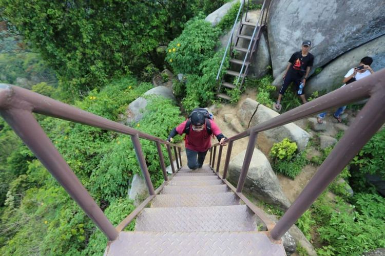 A hiker climbs the steep stairs at SJ88 Peak, a hill in Jember known for its beautiful views. Photo: Radar Jember