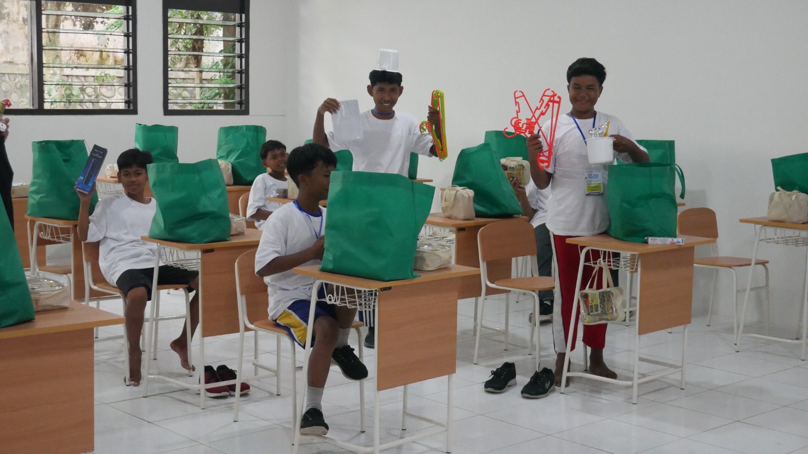 Para siswa Sekolah Rakyat menunjukkan bingkisan yang berisi kebutuhan sehari-hari selama berada di Sekolah Rakyat dan asramanya, Kamis (31/7).